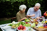 Senior adult couple sitting having salad together