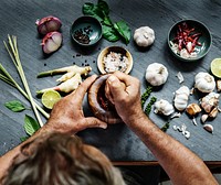 Aerial view of hands crushing asian ingredients with mortar and pestle