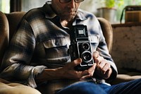 Closeup of senior man using retro classic film camera