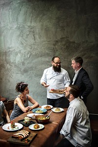 Chef presenting food to customers in the restaurant
