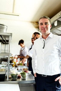 Restaurant kitchen chef with staff and manager