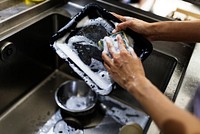 Hands washing kitchenware on the sink