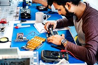 Side view of technicians working on computer electronics parts
