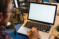 Technician man working on laptop with mockup screen