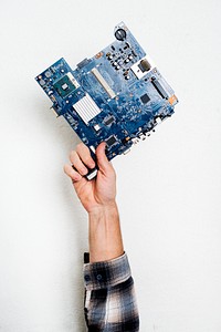 Hand holding motherboard circuit hardware part
