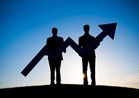 Two Businessmen holding the increase graph on the hill