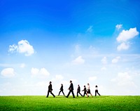 Group Of Business People Walking Through The Field In Daylight.
