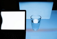 Office desk with a laptop and a glass of water