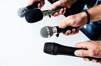 Hands holding microphone point to the same direction