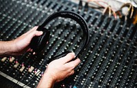 Hand with headphone ona sound mixer
