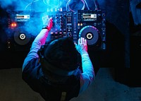 Dj playing music at sound mixer in night club