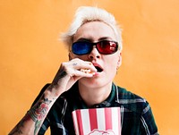 Caucasian tattoo woman with 3D glasses eating pop-corn