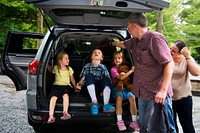 Kids sitting inside open car trunk