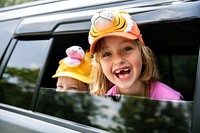 Caucasian girls smiling head out of the car