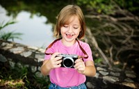 Young caucasian girl smiling with camera in hands