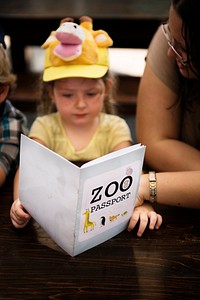 Caucasian girl holding zoo passport activity book