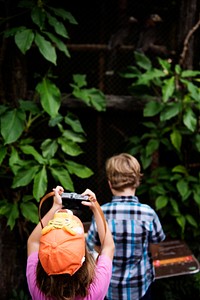 Rear view of young caucasian girl taking photo with camera