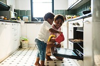 Black kid helping mom baking cookies