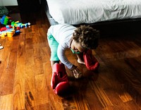 African descent kid with boxing glove on wooden floor
