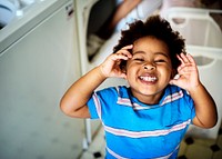 Black kid smiling in the laundry room