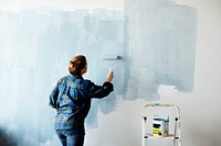 Construction woman painting the wall