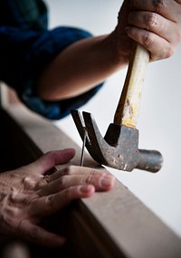 Canpenter using hammer pull a nail out from a wood