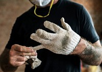 Handyman with tattoo pulling out a glove