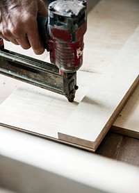 A carpenter using a sawing on a wood
