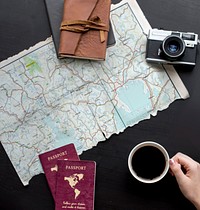 Hand holding a cup of coffee and map on the table