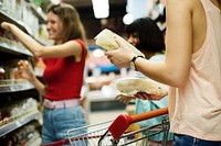 Women choosing food from a supermarket shelf