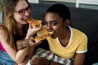 Diverse women eating pizza together
