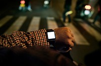 Arm with digital wrist watch at night time