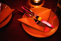 Closeup of fork knife with napkin on the dish in the restaurant table setting