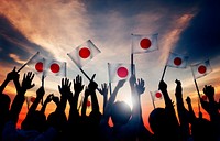 Silhouettes of People Holding the Flag of Japan