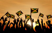 Group of People Waving Flag of Jamaica in Back Lit