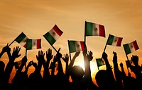Group of People Waving Mexican Flags in Back Lit
