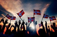Group of People Waving Norwegian Flags in Back Lit