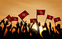 Group of People Waving Switzerland Flags in Back Lit