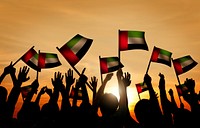 Group of People Waving Flag of UAE in Back Lit