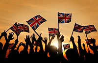 Group of People Waving UK Flags in Back Lit