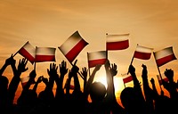 Group of People Waving Polish Flags in Back Lit