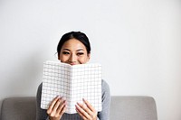 Woman face covered with notepad on white background