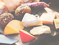 Closeup of various cheeses on wooden table with buns