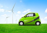 Electric green car in the outdoor with a view of windmill behind it.