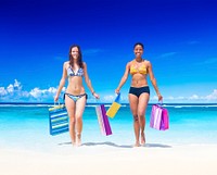 Women with shopping bags on a tropical beach.