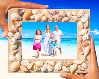 Family having fun on the beach with picture frame.