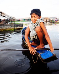 Boy traveling by boat in floating village