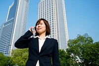 Asian businesswoman working by skyscrapers.