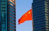 The Chinese flag with a modern building background.