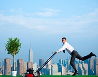 Green businessman in the city mowing lawn.